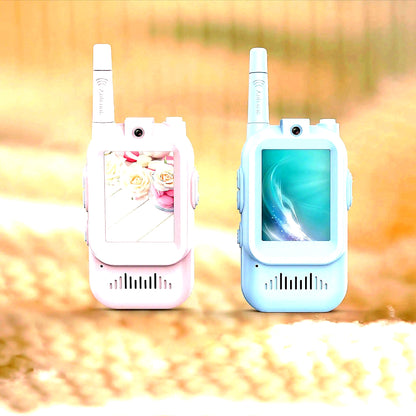 Pink and blue rechargeable video walkie talkies for kids standing side by side on a soft indoor surface